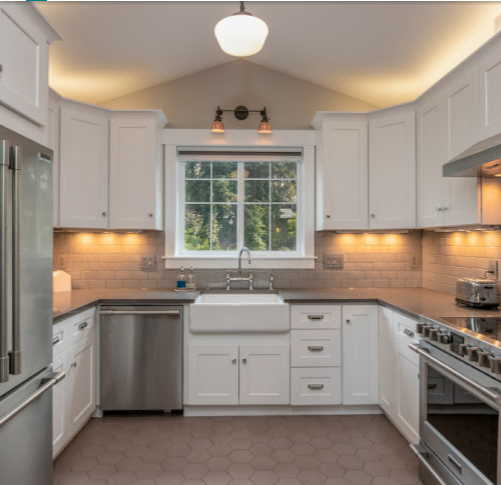 Bright white kitchen renovation with farmhouse sink and custom cabinetry